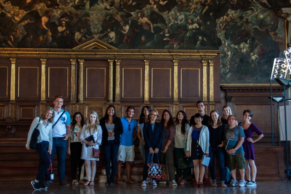 Each day's choice of monuments is based on a walkable itinerary, visiting churches, confraternities, cloisters, palaces, and museums. Group of students standing within the frescoed Sala del Maggior Consiglio