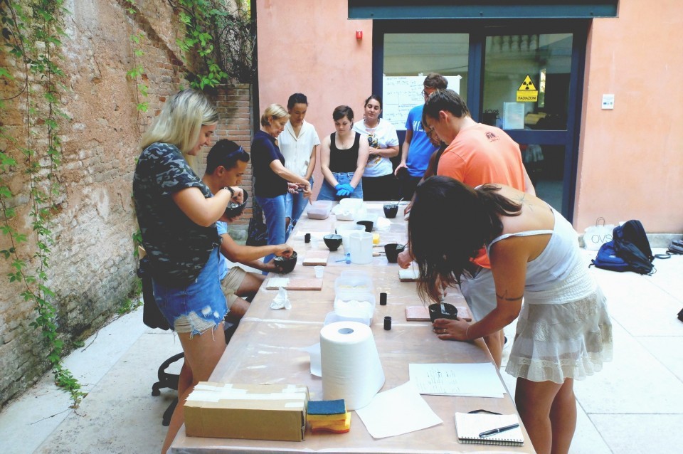 Conservation courses provide participants with an understanding of the built heritage of Venice, its historical development, construction, and the related preservation requirements. Group of students surrounding a table, examining conservation materials