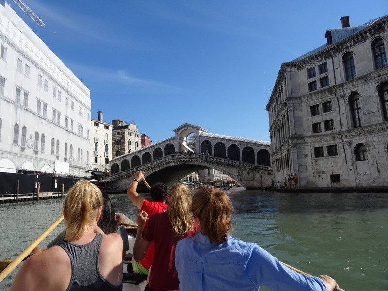 Four girls in a gondola approaching Rialto Bridge 
