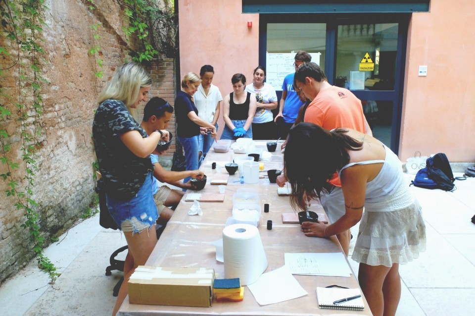 Group of students surrounding a table, examining conservation materials